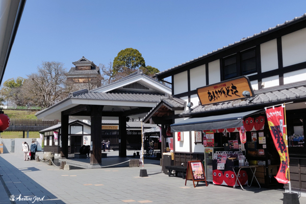 Les boutiques de Sakura no baba avec la tour Hitsuji-Saru 熊本城 未申櫓 au fond